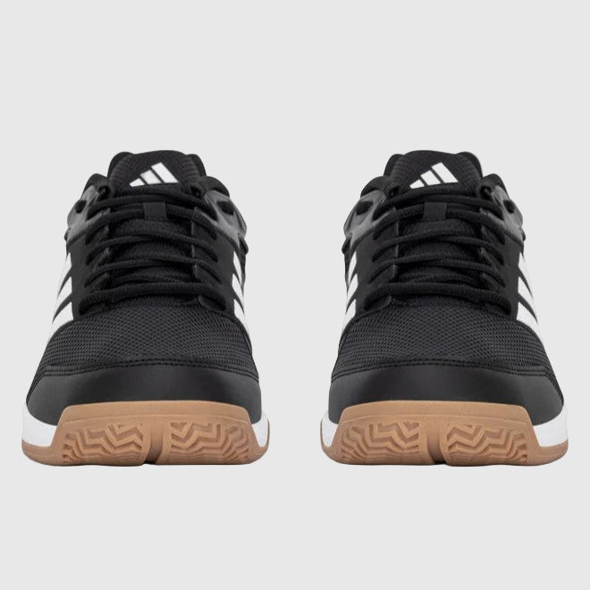 Black Adidas shoes with white stripes on a grey background